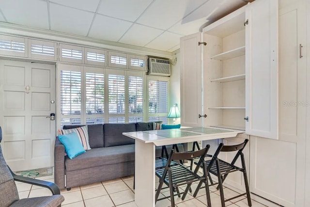 dining space featuring a wall mounted AC, light tile patterned flooring, and a paneled ceiling