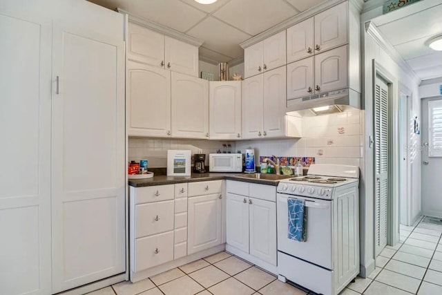 kitchen with light tile patterned floors, white appliances, a sink, and under cabinet range hood