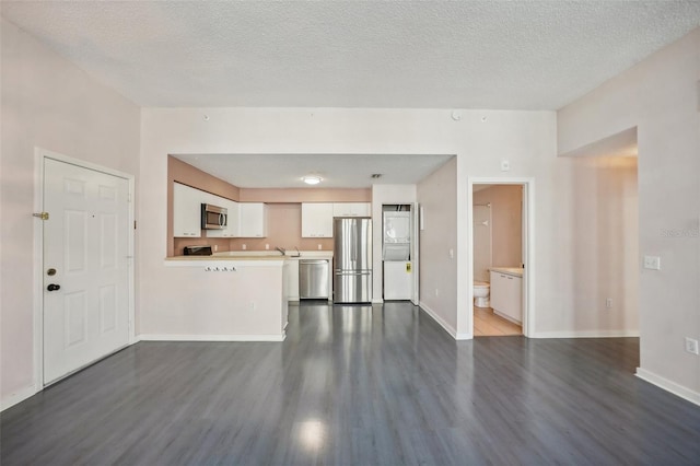 unfurnished living room with a textured ceiling and dark hardwood / wood-style flooring