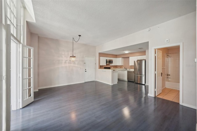 unfurnished living room with a textured ceiling and wood-type flooring