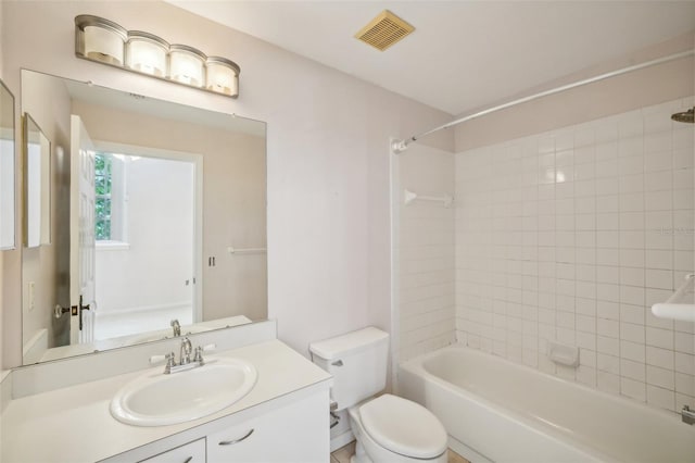 full bathroom featuring toilet, tiled shower / bath, and vanity