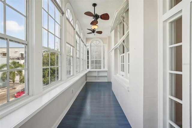 unfurnished sunroom with ceiling fan