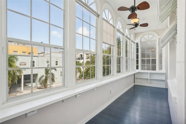 unfurnished sunroom with ceiling fan