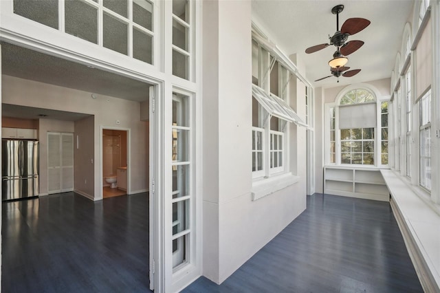 unfurnished sunroom with ceiling fan