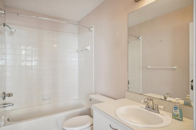 full bathroom featuring vanity, tiled shower / bath combo, and toilet