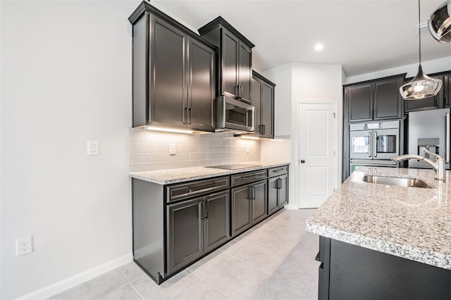 kitchen with pendant lighting, sink, light tile patterned floors, and tasteful backsplash