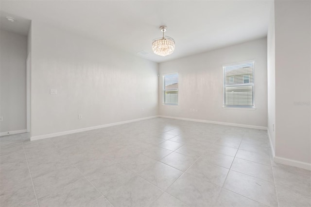 empty room featuring light tile patterned floors and a chandelier