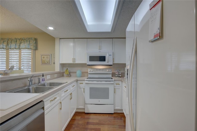 kitchen featuring white cabinetry, dark hardwood / wood-style floors, sink, a textured ceiling, and white appliances