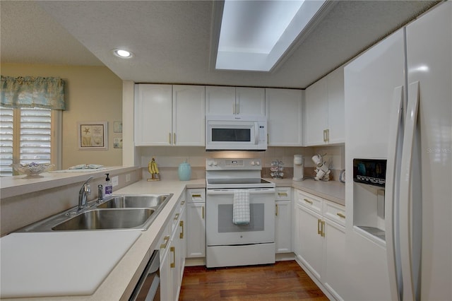 kitchen with sink, white appliances, dark hardwood / wood-style floors, a textured ceiling, and white cabinetry