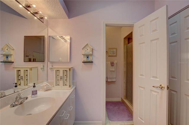 bathroom featuring a shower with shower door, vanity, and tile patterned floors