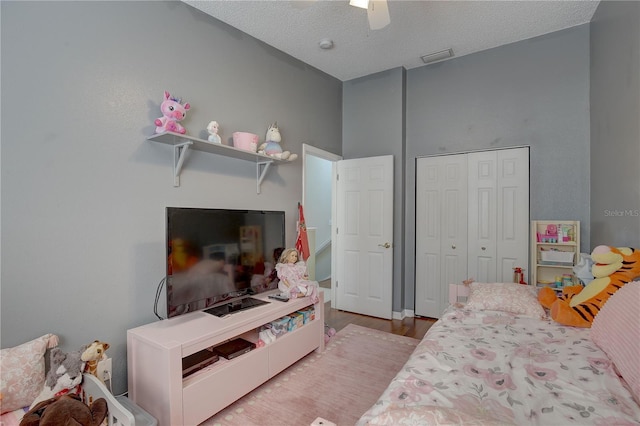 bedroom featuring a closet, ceiling fan, a textured ceiling, and wood finished floors