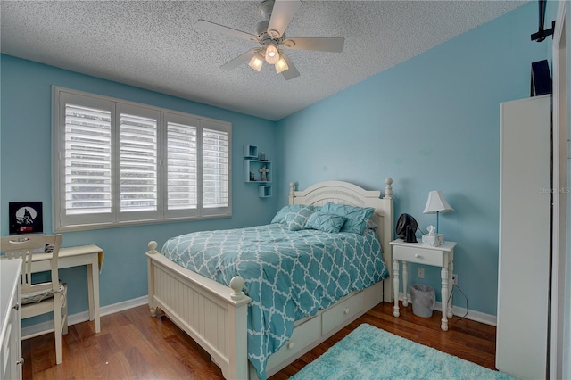 bedroom with ceiling fan, a textured ceiling, baseboards, and wood finished floors