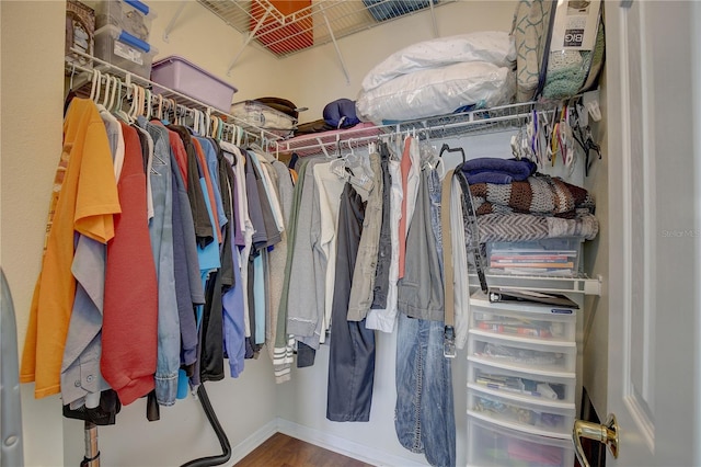 walk in closet with wood finished floors