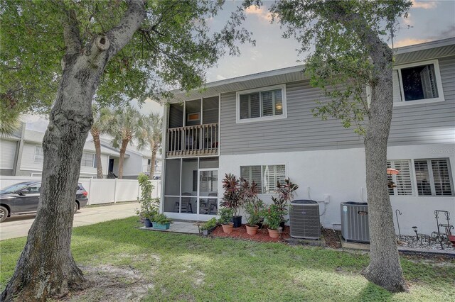 exterior space featuring a balcony, a yard, and cooling unit