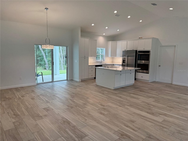 kitchen with a kitchen island, light hardwood / wood-style flooring, and high vaulted ceiling