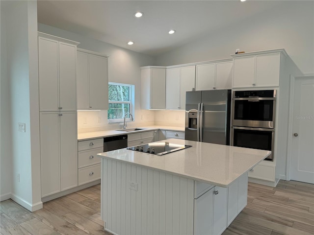 kitchen with a center island, backsplash, sink, and appliances with stainless steel finishes