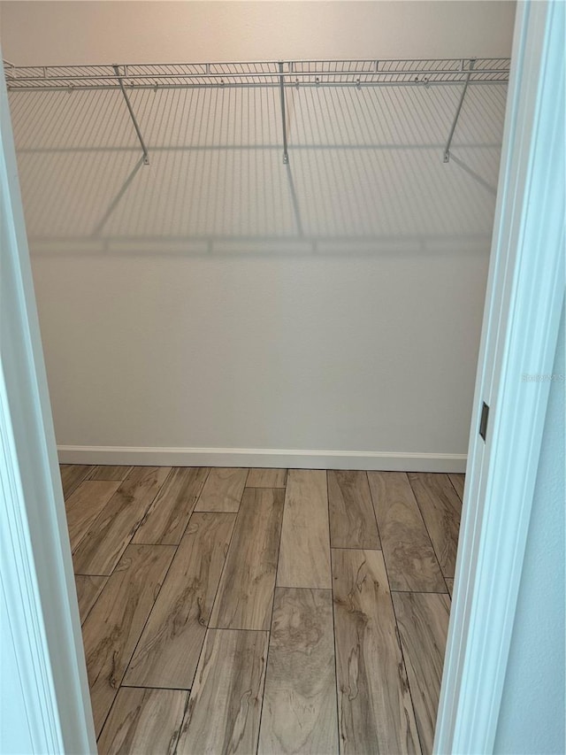 walk in closet with hardwood / wood-style floors