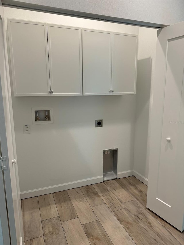 laundry area featuring light hardwood / wood-style floors, cabinets, hookup for a washing machine, and hookup for an electric dryer