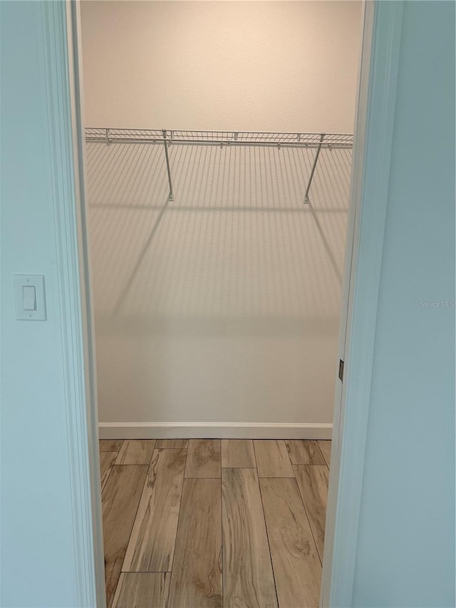 spacious closet with light hardwood / wood-style flooring