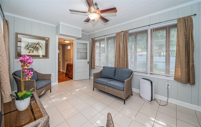 living area with ceiling fan, ornamental molding, and tile patterned floors