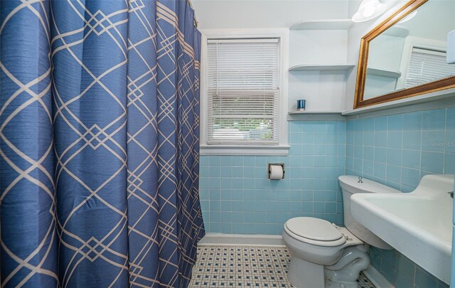 bathroom with tile walls, tile patterned flooring, walk in shower, and toilet