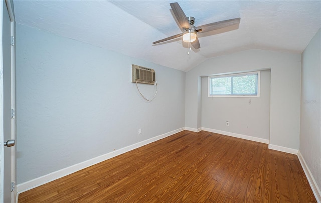 unfurnished room featuring ceiling fan, lofted ceiling, wood-type flooring, and a wall mounted air conditioner