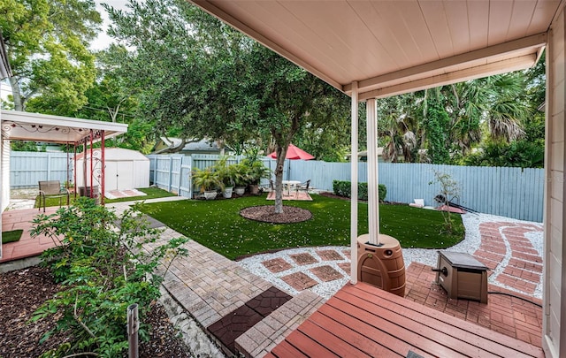 exterior space with a lawn, a patio, and a shed