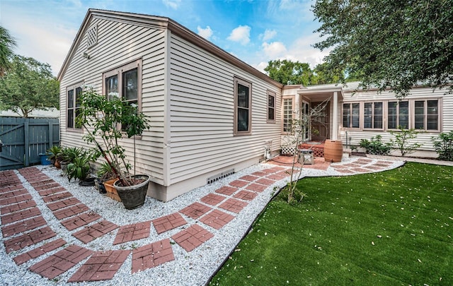 rear view of house featuring fence and a lawn