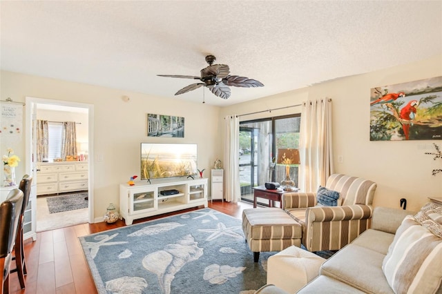 living area featuring ceiling fan, a textured ceiling, and wood finished floors