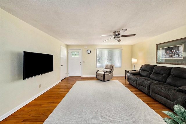 living room featuring ceiling fan, hardwood / wood-style flooring, and a textured ceiling