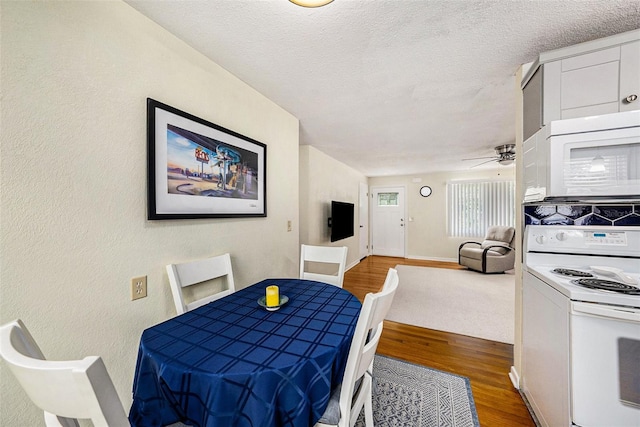 dining room featuring ceiling fan, hardwood / wood-style floors, and a textured ceiling