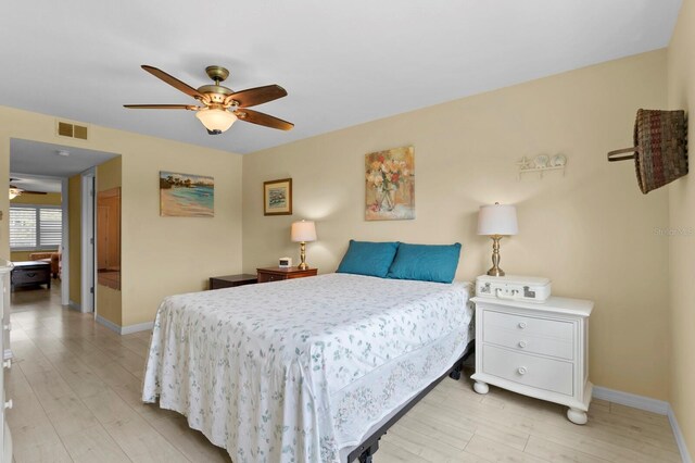 bedroom with ceiling fan, light hardwood / wood-style floors, and a closet