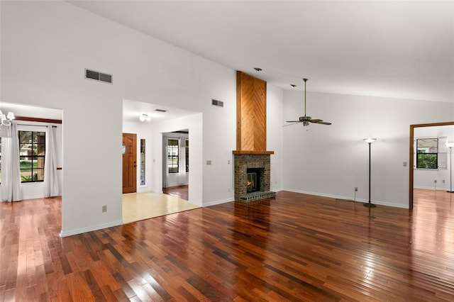 unfurnished living room featuring wood-type flooring, high vaulted ceiling, ceiling fan, and a brick fireplace