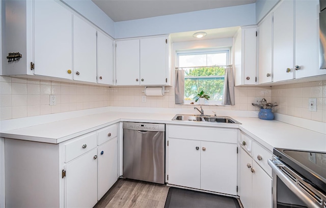 kitchen with decorative backsplash, white cabinets, light hardwood / wood-style floors, dishwasher, and sink