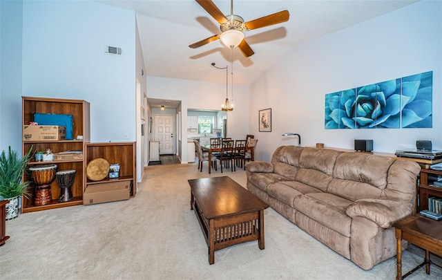 living room with high vaulted ceiling, ceiling fan, and light carpet