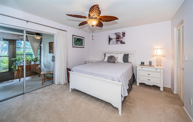 carpeted bedroom with ceiling fan and a textured ceiling