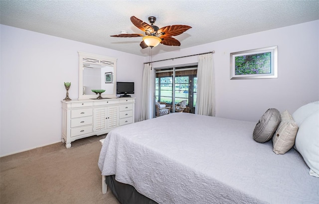 bedroom featuring ceiling fan, light colored carpet, a textured ceiling, and access to exterior