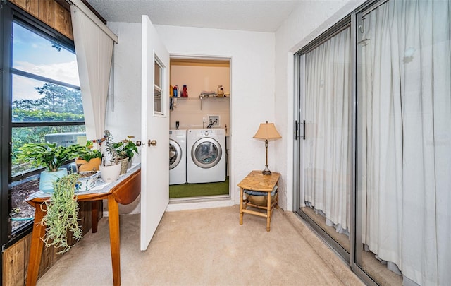 interior space featuring washing machine and dryer, light colored carpet, and a textured ceiling