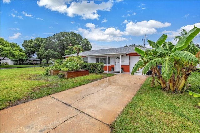 view of front facade with stucco siding, concrete driveway, a garage, a garden, and a front lawn