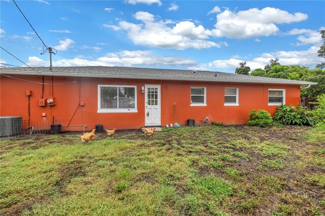 ranch-style home with a front lawn and central air condition unit