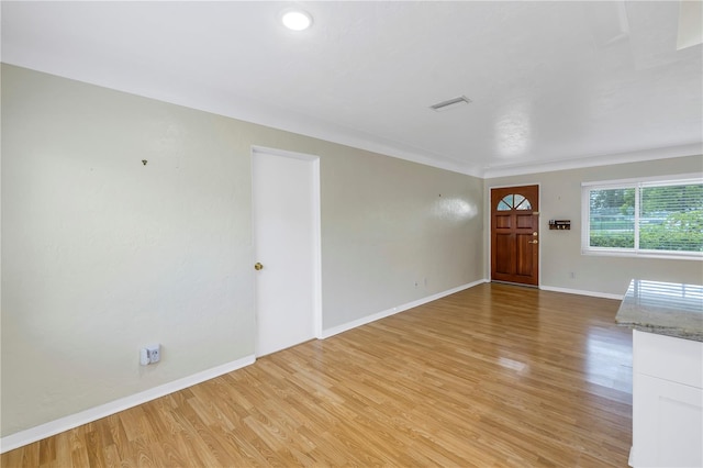 empty room featuring crown molding and light hardwood / wood-style flooring