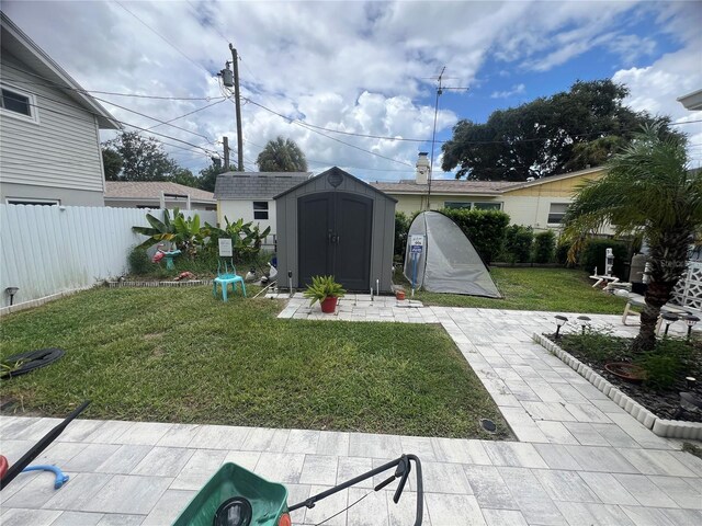 view of yard with a storage unit and a patio area