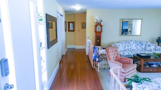 corridor with baseboards and wood finished floors