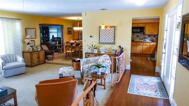 carpeted living room with a notable chandelier