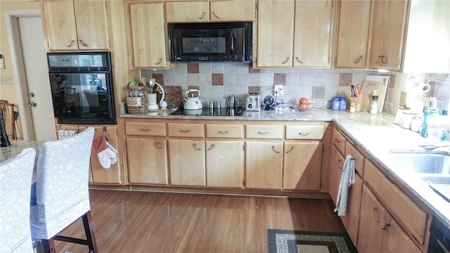 kitchen featuring black appliances, dark wood-style flooring, and backsplash