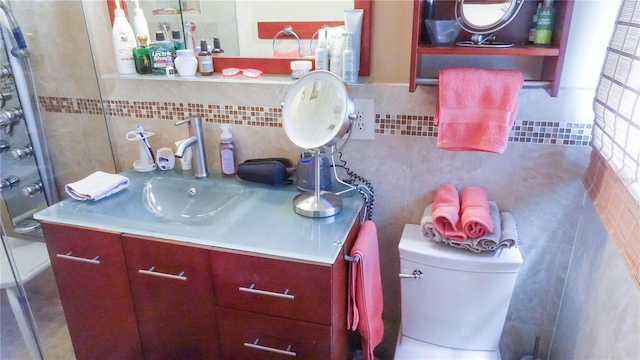 bathroom featuring toilet, tile walls, and vanity