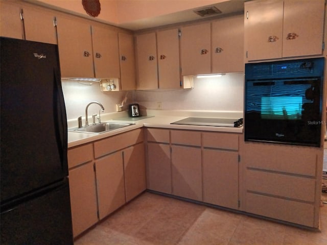 kitchen with sink, black appliances, and light tile patterned floors