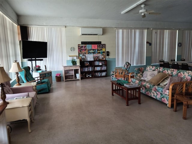 living room featuring ceiling fan, concrete floors, and a wall unit AC