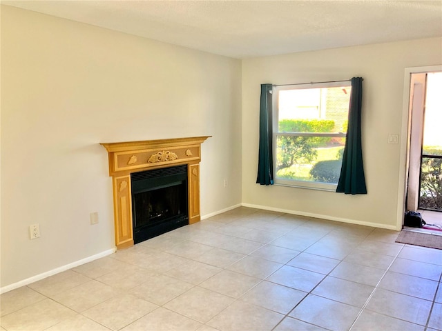 unfurnished living room with a fireplace, light tile patterned flooring, and baseboards