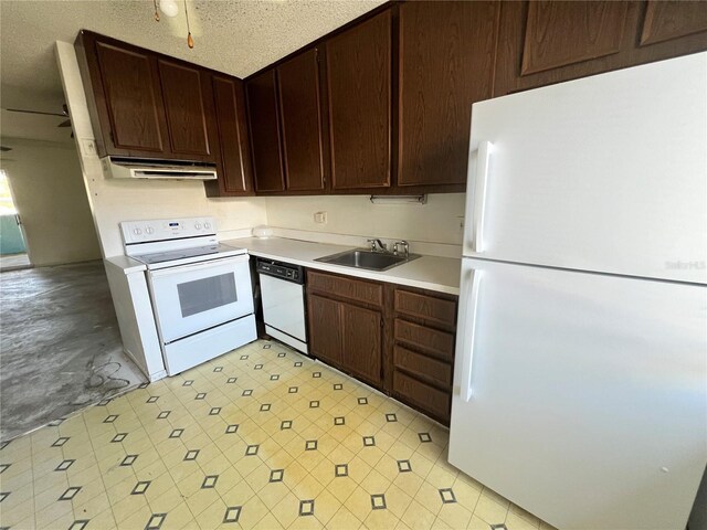 kitchen featuring dark brown cabinetry, under cabinet range hood, white appliances, a sink, and light countertops